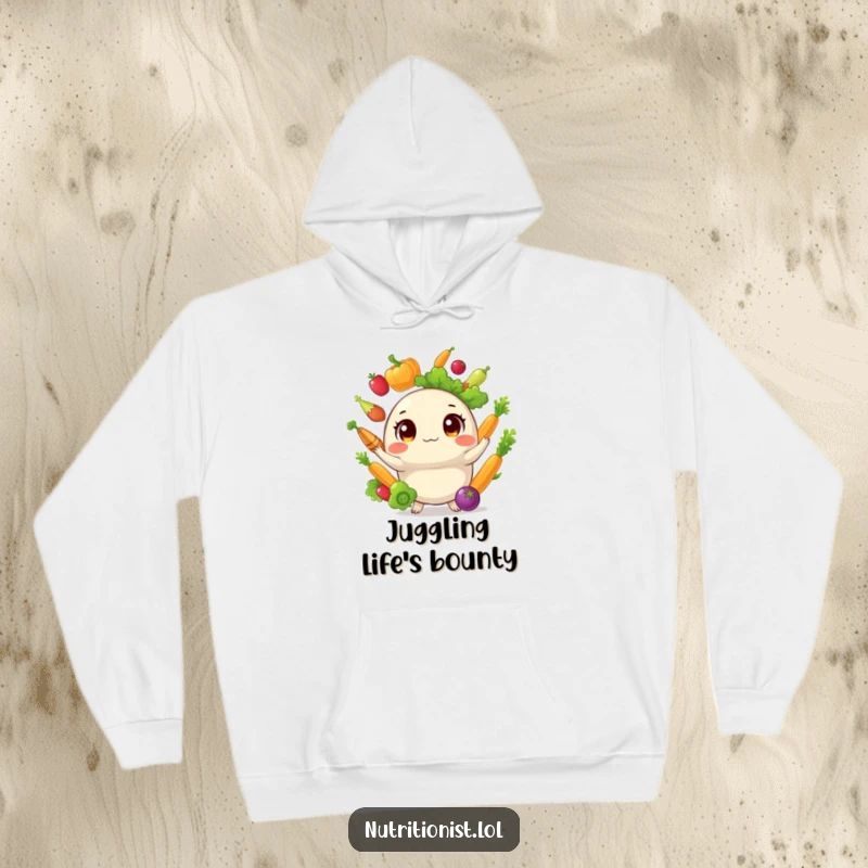 Funny hoodie with a cozy fit, depicting a round, cheerful creature juggling an assortment of healthy vegetables with impressive dexterity and a big smile.